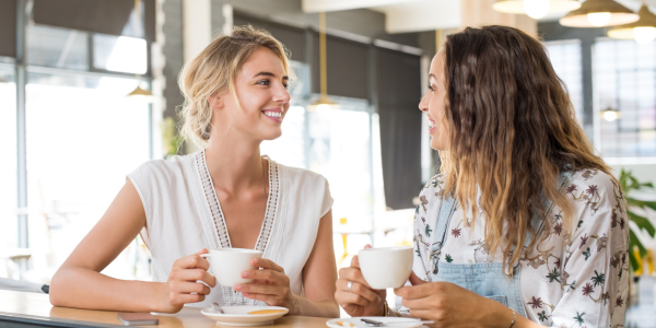 Two women smiling during a private Akashic Records mini-reading at an energy healing party in Phoenix