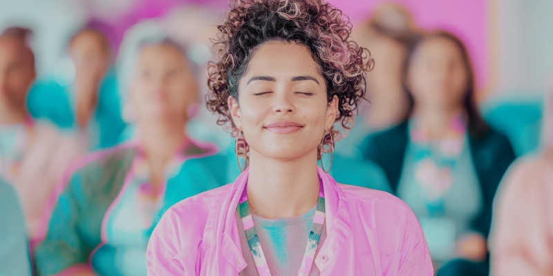 Mujer con los ojos cerrados y una suave sonrisa, vestida con colores pastel, disfrutando de una clase de reprogramación mental.